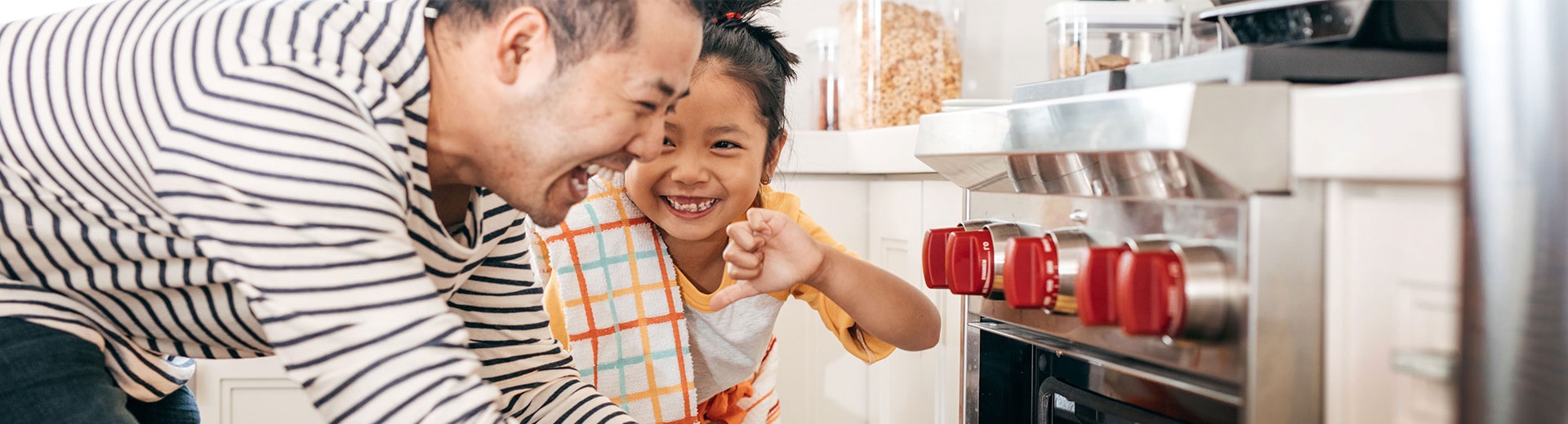 Dad and daughter smiling in the kitchen